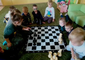 Dzieci oglądają figury szachowe